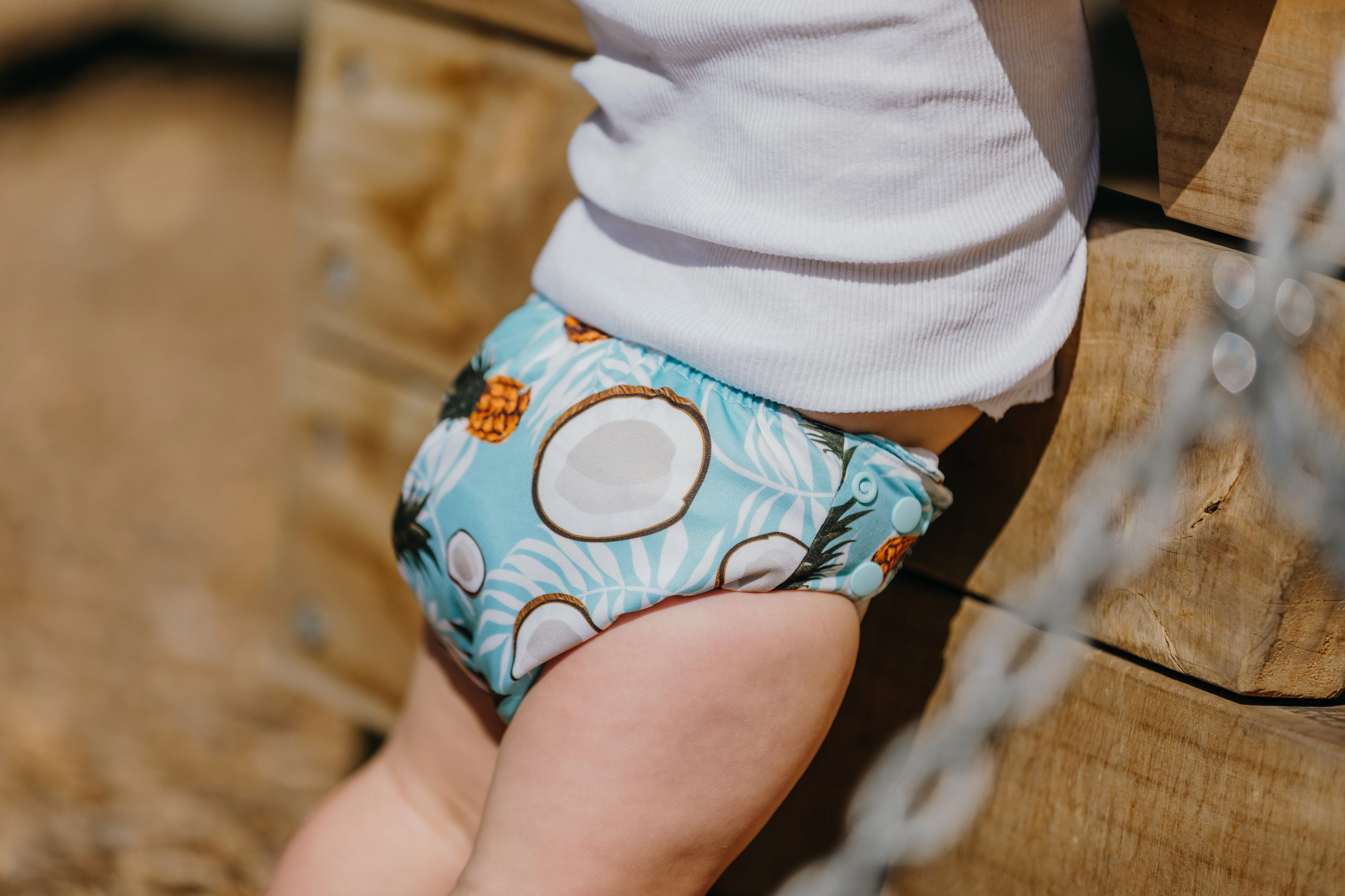Close-up of Pina Coca nappy showing snap buttons and inserts