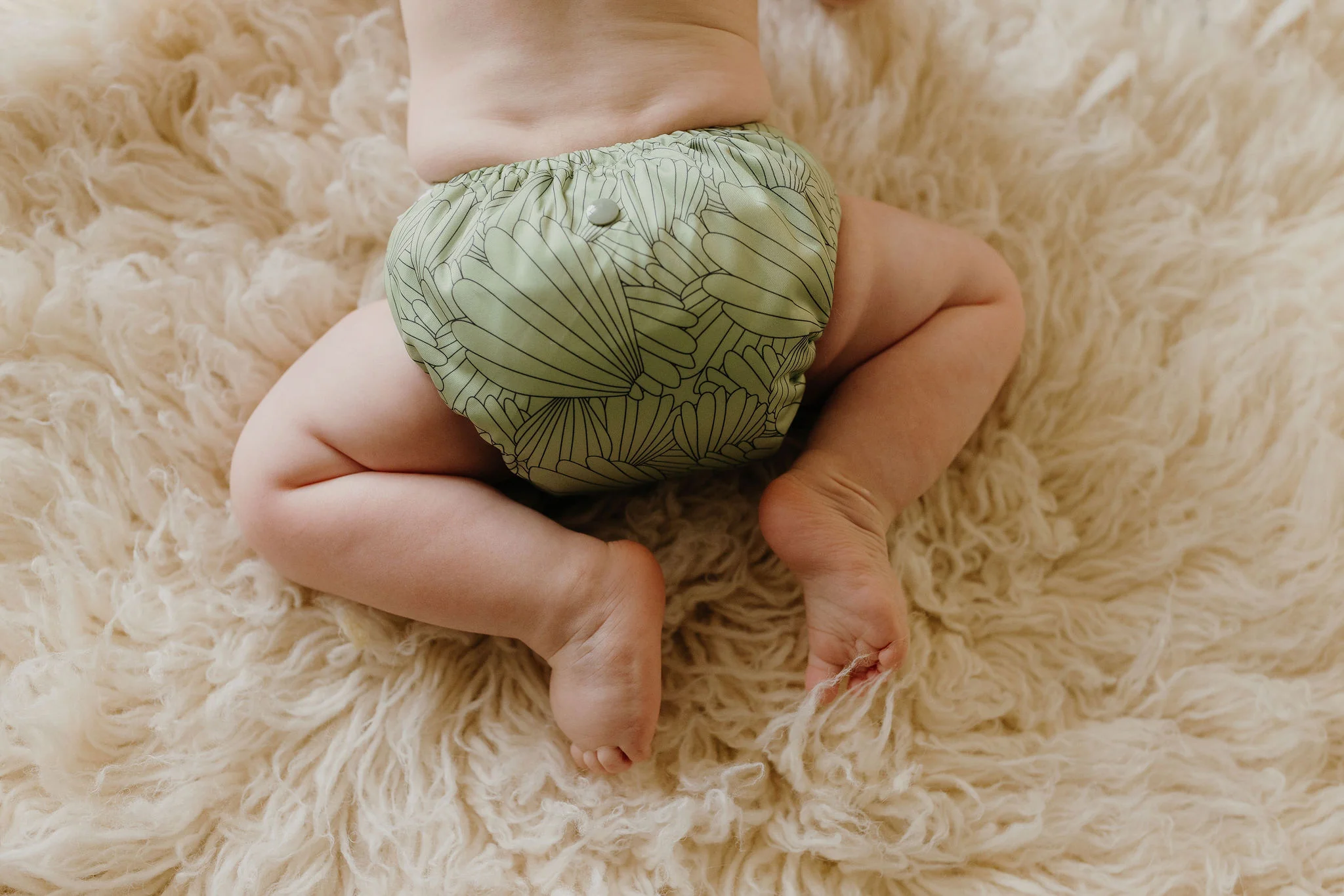 Close-up of Flutter OSFM nappy showing snap buttons and bamboo inserts